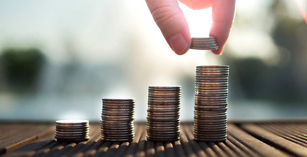 Monete impilate in crescita che rappresentano la liquidità aziendale ottenuta attraverso la cessione del credito pro soluto.